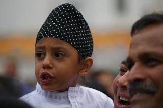 Kevin J Mansell; Bollywood Crowd;  was standing at the front of the stage and turned around to see the crowds behind me. The little boy with the 'head scarf' on caught my eye as did the expressions on the faces of the two men.